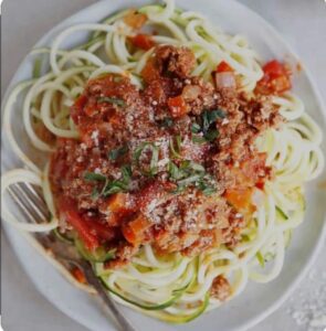 A plate of delicious spiraled zucchini with bolognese sauce.